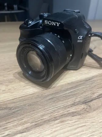 Камера Sony Alpha 3000 с объективом на деревянной поверхности