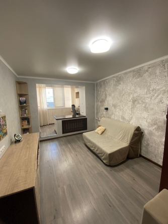 Современная спальня с кроватью и мягким текстилем на стенах