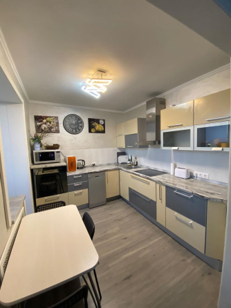 Современная спальня с кроватью и мягким текстилем на стенах