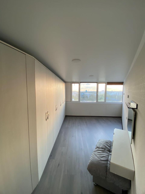 Просторная комната с окнами и зеркальным шкафом