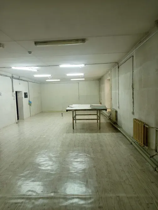 Просторное помещение с освещением и столом в центре