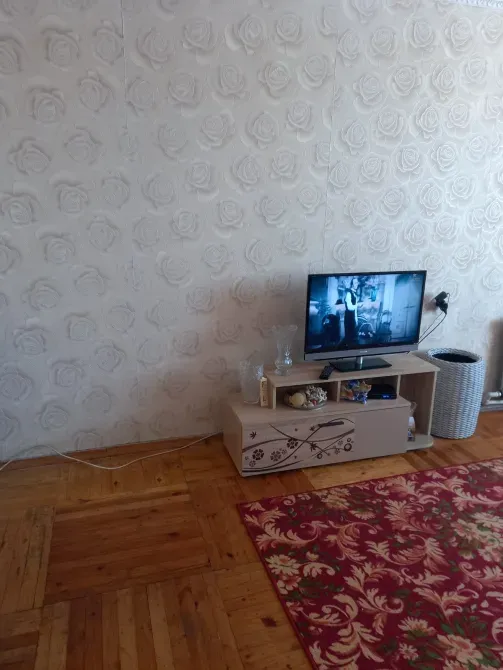 Гостиная с телевизором на стене и ковром