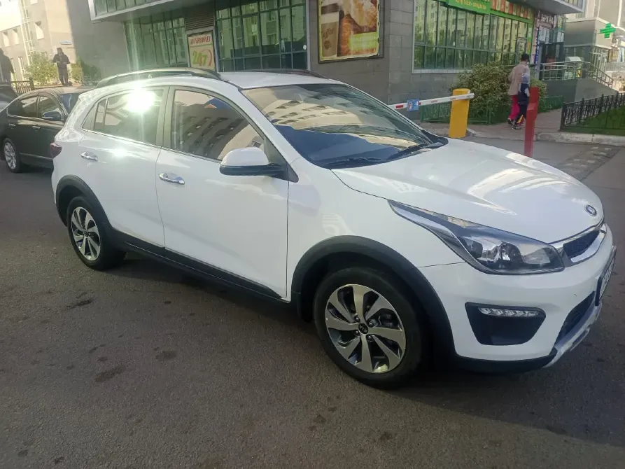 Автомобиль Kia белого цвета с современным дизайном на улице