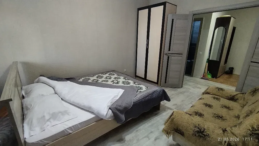 Спальня с двуспальной кроватью и диваном, вид на шкаф