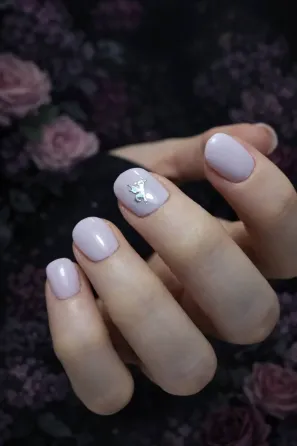 Көркем маникюр және сақиналары бар қолдың бейнесі жарық матаның фонында