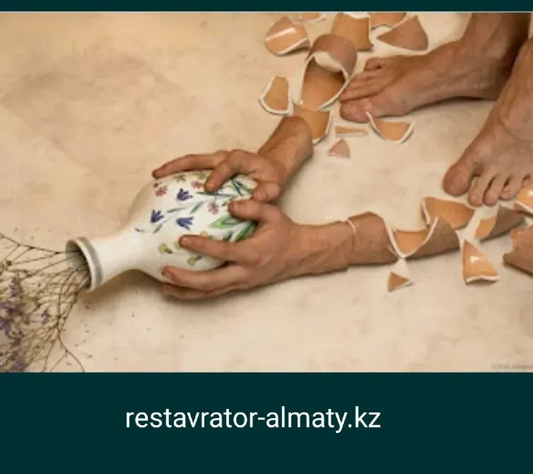 Человек держит разбитую вазу, много осколков на полу