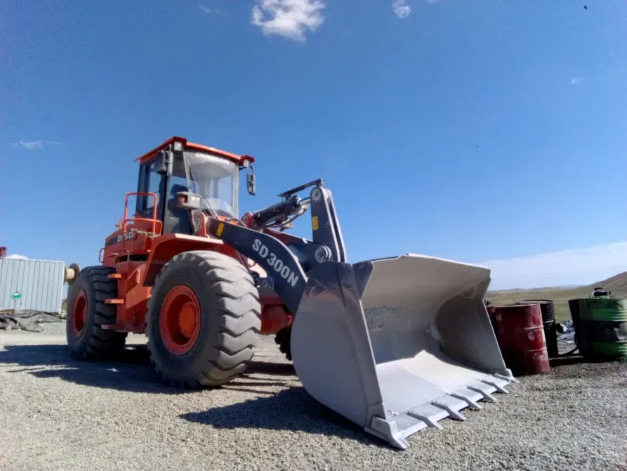 Экскаватор-погрузчик на строительной площадке под ясным небом