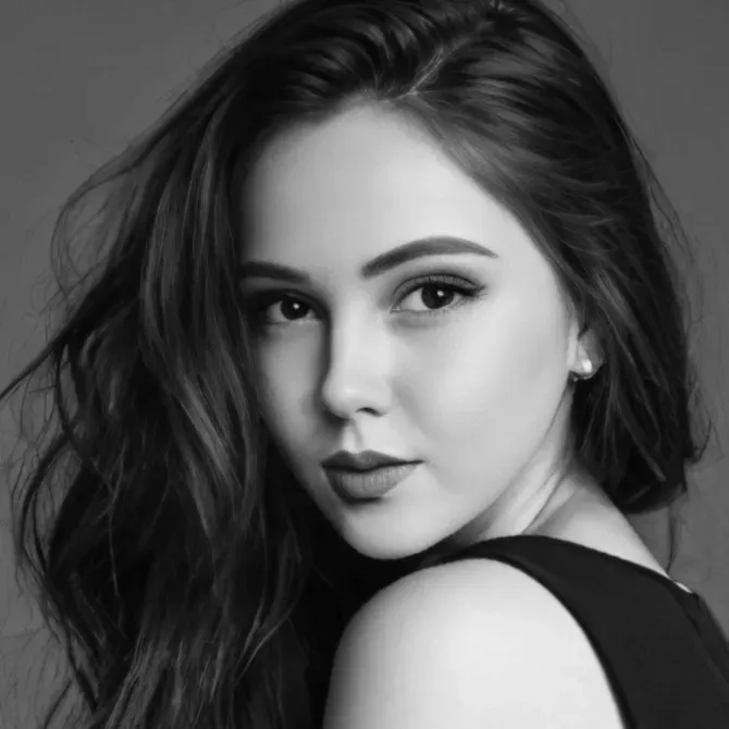 Портрет молодой женщины с длинными темными волосами, смотрящей через плечо в черно-белом исполнении