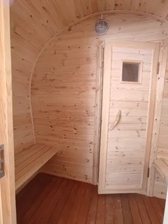 Массажная баня с деревянной наружной отделкой и крышей в форме арки