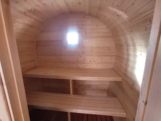 Массажная баня с деревянной наружной отделкой и крышей в форме арки