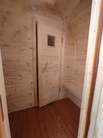 Массажная баня с деревянной наружной отделкой и крышей в форме арки