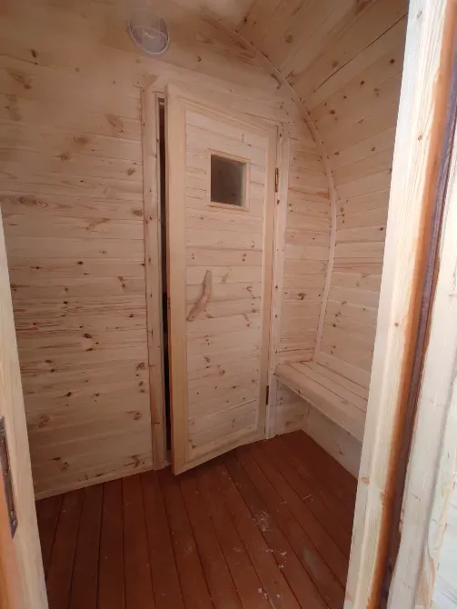 Вид изнутри бани, показывающий входную дверь и стены из дерева