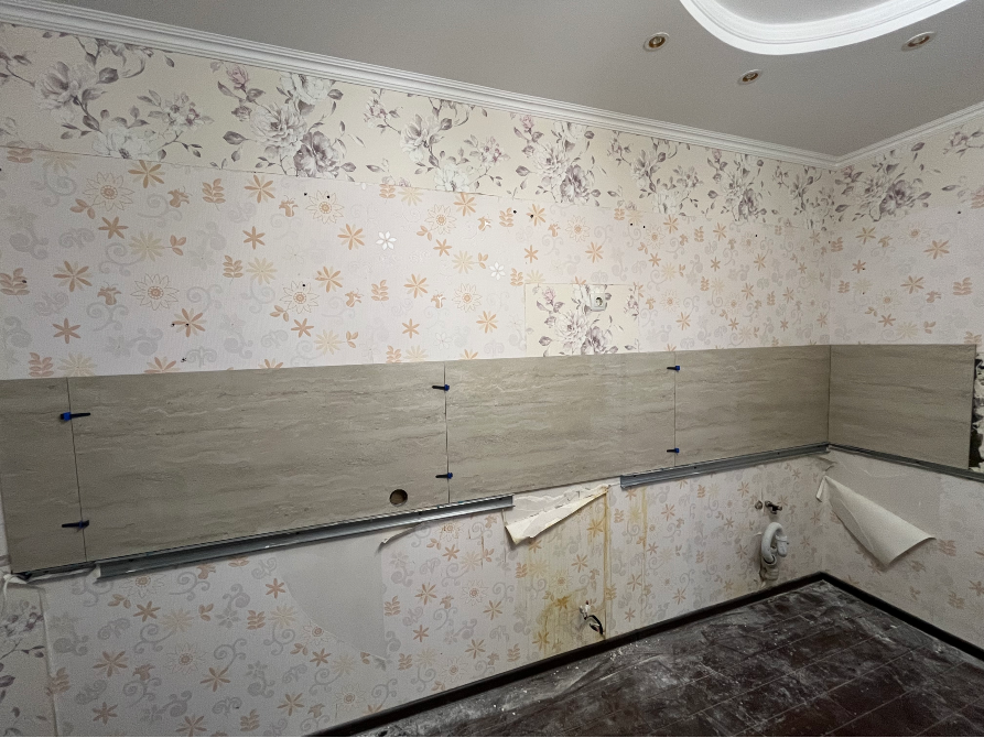 Стена с укладкой плитки на фоне цветочных обоев