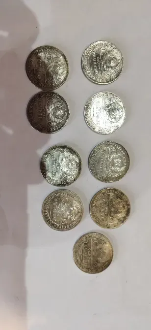 Монеты серебряного цвета, выставленные в ряд на белом фоне