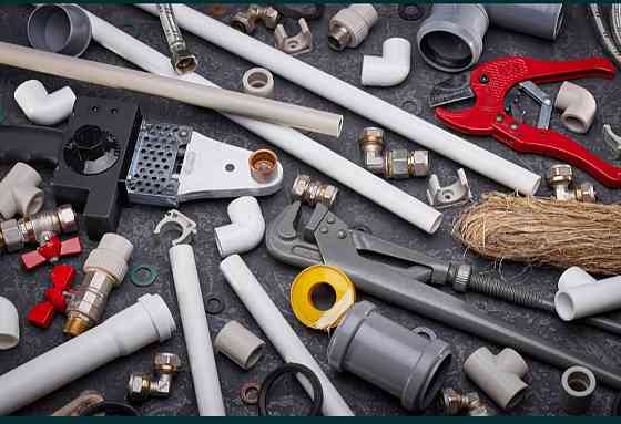 Разнообразие сантехнических инструментов и материалов, включая трубы, фитинги, гайки и обжимные инструменты