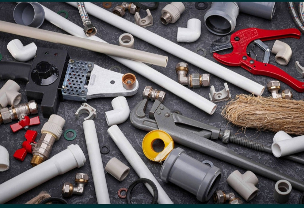 Разнообразие сантехнических инструментов и материалов, включая трубы, фитинги, гайки и обжимные инструменты