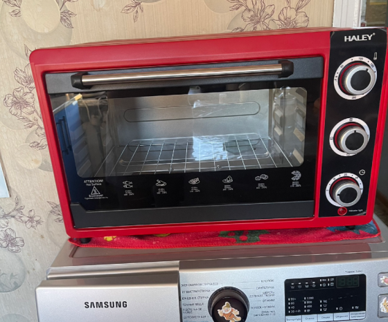 Духовка Haley красного цвета, стоит на кухонной поверхности