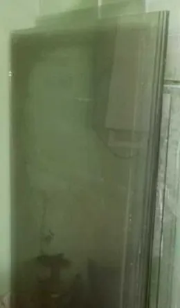 Стеклянные панели, стоящие вертикально на полу, отражают окружающее пространство