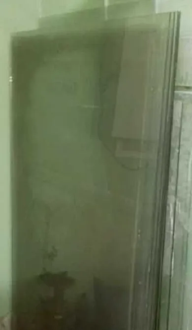 Стеклянные панели, стоящие вертикально на полу, отражают окружающее пространство