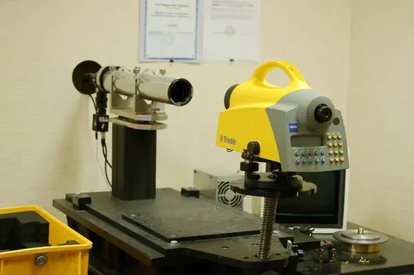 Техническое оборудование для измерений, включая уровень и оптические приборы на столе в лаборатории