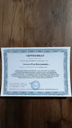 Квалифицированный массажист в студии, поза с перекрещенными руками на фоне зелени