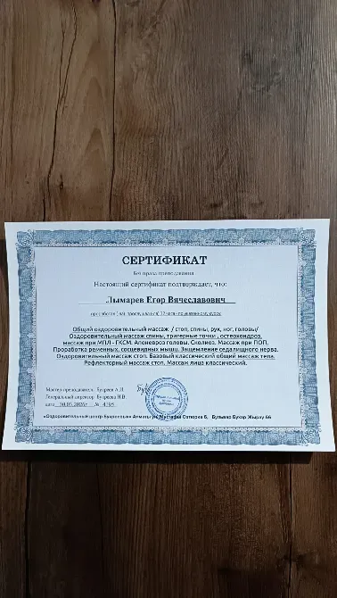 Сертификат массажиста на деревянном фоне