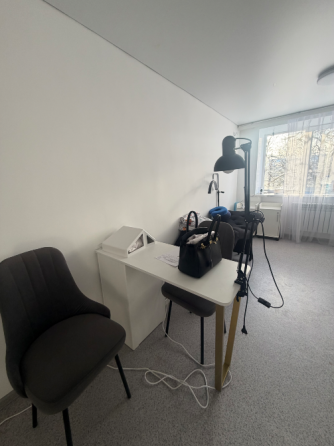 Интерьер парикмахерской с зеркалом и креслом, украшенным зеленым пледом