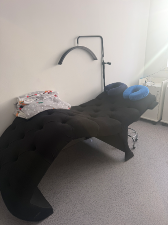 Интерьер парикмахерской с зеркалом и креслом, украшенным зеленым пледом