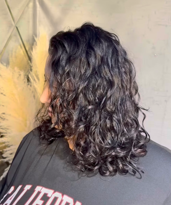 Женщина с кудрявыми волосами, смотрящая в сторону