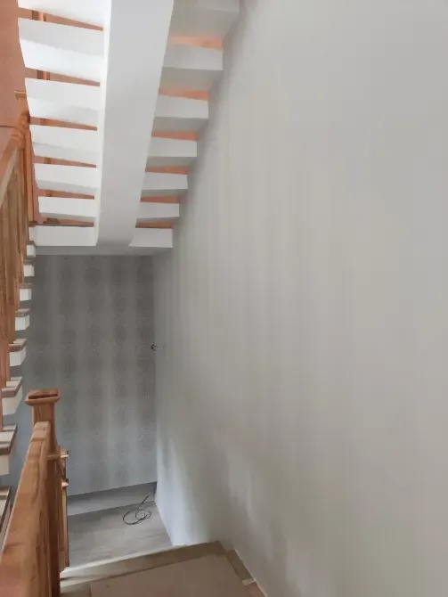 Лестница с перилами и светло-серыми стенами