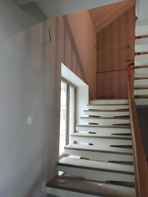 Лестница с деревянными перилами и окном, ведущим на улицу