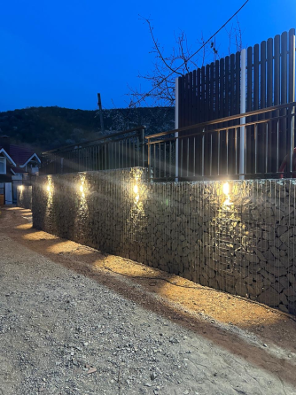 Светящаяся стена из габионов на фоне ночного неба