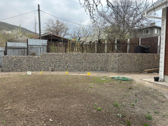 Светящаяся стена из габионов на фоне ночного неба