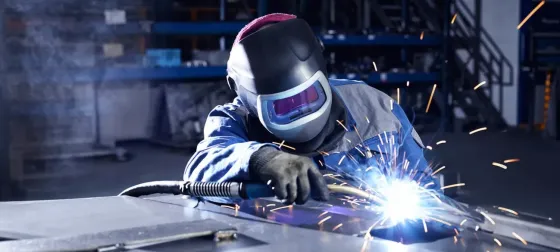 Сварщик электросваркамен жұмыс істейді