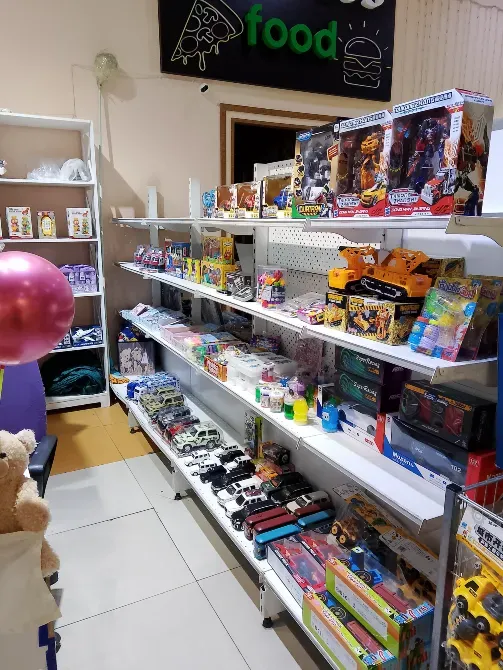 Полки с товарами: игрушки, фигурки и настольные игры в магазине