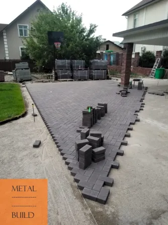 Работы по укладке плитки на улице с людьми, укладывающими плитку