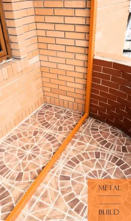 Металлдан жасалған шатыр және қызғылт сары элементтері бар кірпіш қабырғалар