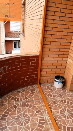 Металлдан жасалған шатыр және қызғылт сары элементтері бар кірпіш қабырғалар