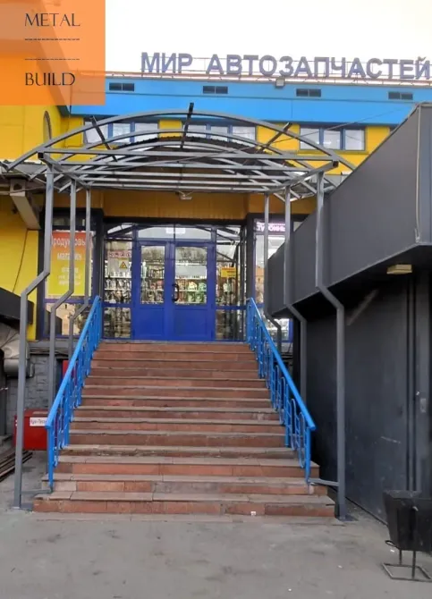 Вход в магазин автозапчастей с крытой лестницей и ярким оформлением