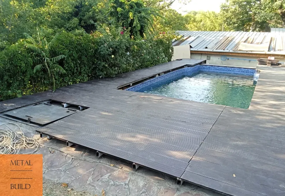 Вид на террасу вокруг бассейна с деревянным настилом и зелеными насаждениями