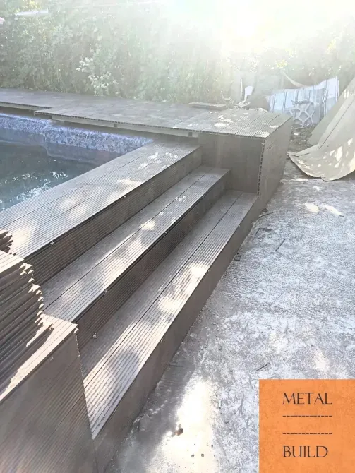 Деревянные ступени рядом с бассейном, освещенные солнечными лучами