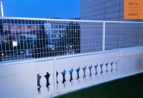 Балкон с металлическим ограждением на фоне вечернего неба