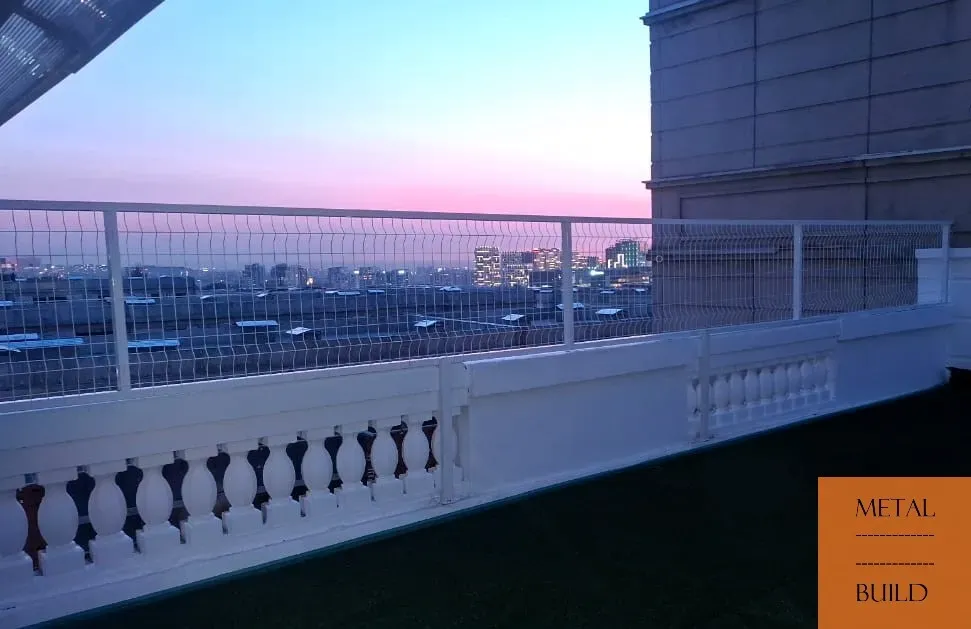 Балкон с металлическим ограждением на фоне вечернего неба