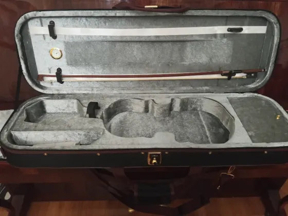 Чёрный футляр для музыкального инструмента на деревянной поверхности