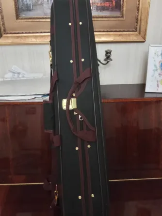 Чёрный футляр для музыкального инструмента на деревянной поверхности