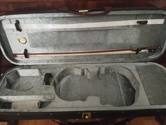 Чёрный футляр для музыкального инструмента на деревянной поверхности