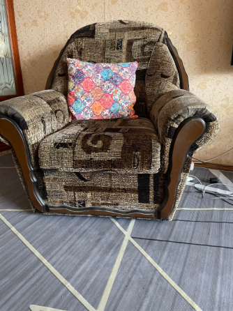 Жұмсақ диван жарқын жастықпен, жарықты қабырға декорының фонында