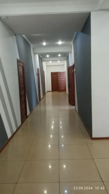 Коридор с открытыми дверями, светлая отделка стен и потолков