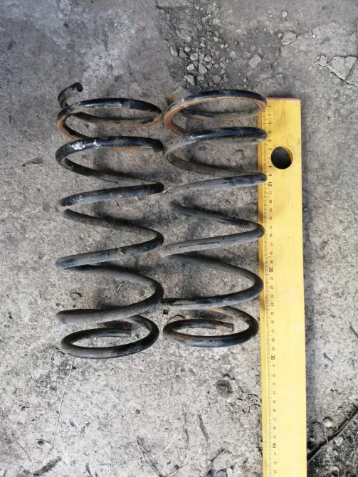 Пружины, расположенные на земле, с линейкой для измерения длины