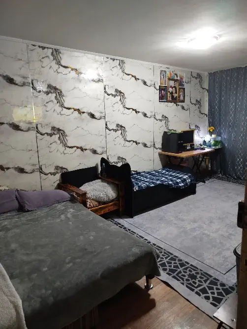 Комната с двумя кроватями и рабочим столом на фоне стен с рисунком